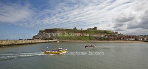 Boats carrying day trippers are a common sight on the sheltered waters of the harbour at Whitby in Yorhshire, England.