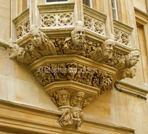 Sculpture below window of historic building in the city of Oxford, England.