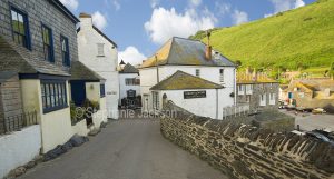 Narrow street, houses / cottages and harbour in the village of Port Isaac in Cornwall, England.