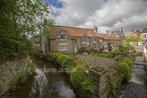 Houses and tea room beside stream at the village of Thornton-le-Dale, also known as Thornton Dale, in North Yorkshire, England.