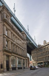 The historic Tyne Bridge above the roofs of historic buildings in the city of Newcastle-upon Tyne / Newcastle in Northumberland, England.