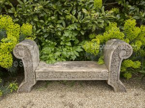Carved wooden bench in gardens at Arundel castle, England.