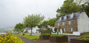 Waterfront cottages / houses beside Loch Carron in the village of Lochcarron in Scotland on a misty morning