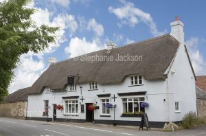 Historic British pub with thatched roof, the Rose and Crown, in the English village of Longburton in Dorset.