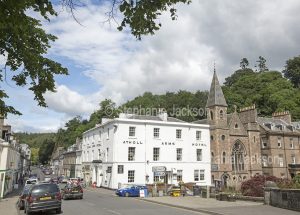 The Atholl Arms Hotel and a church stand side by side in the Scottish town of Dunkeld.