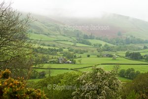 Rural landscape with farm fields on a misty morning near Rhayader in Wales.