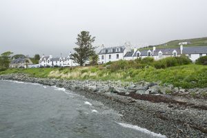 White painted cottages / houses line the foreshore at the coastal village of Stein on the Isle of Skye in Scotland.