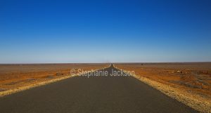 Outback road across treeless plains in northern South Australia